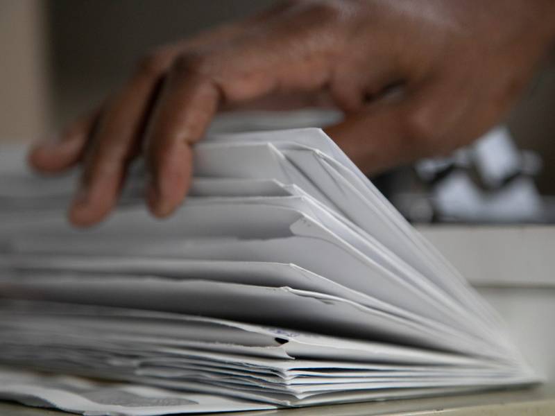 ﻿﻿Darrell Siggers leafs through mail from inmates looking for help