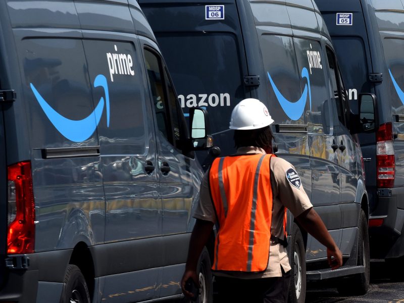 Amazon vans line up at a distribution center to pick up packages for delivery on Amazon Prime Day, July 16, 2019, in Orlando, Florida.
