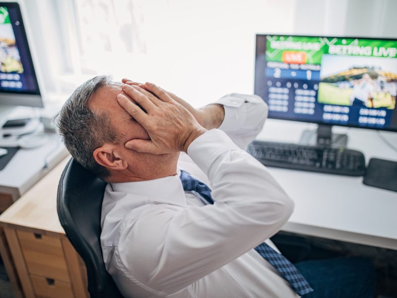 Senior business man live betting at his home office and losing. Via Getty Images