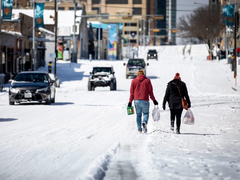 People carry groceries through the snow in Austin, Texas.