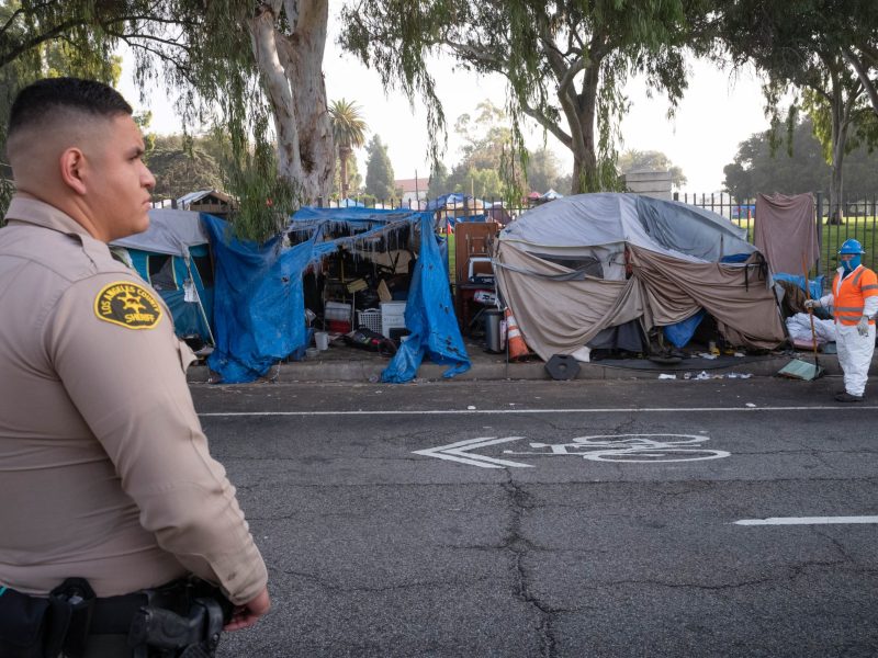 Los Angeles county sheriff deputies stand by as crews begin removing a homeless encampment in front of the Veterans Administration in Westwood, CA, on Nov. 1, 2021.