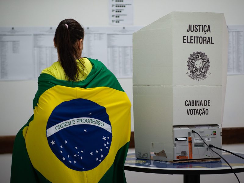 Voters with Brazilian flag during presidential election day on Oct. 2, 2022 in Águas Claras, Distrito Federal, Brazil. After a polarized campaign between Lula and Bolsonaro, the largest Latin American nation votes for president amid an economic crisis.