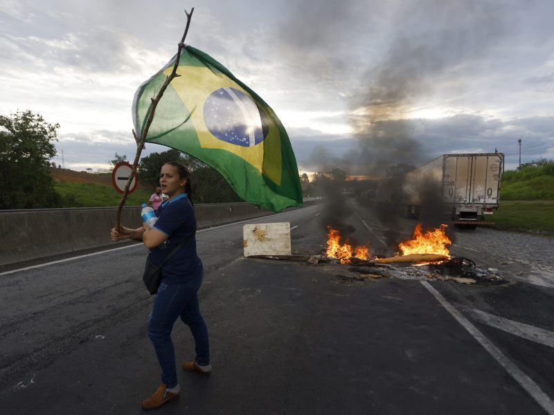 A demonstrator waves a Brazilian flag