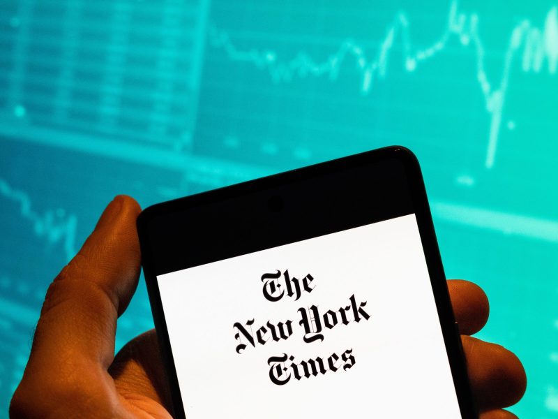 Photo of a phone screen with The New York Times banner displayed.