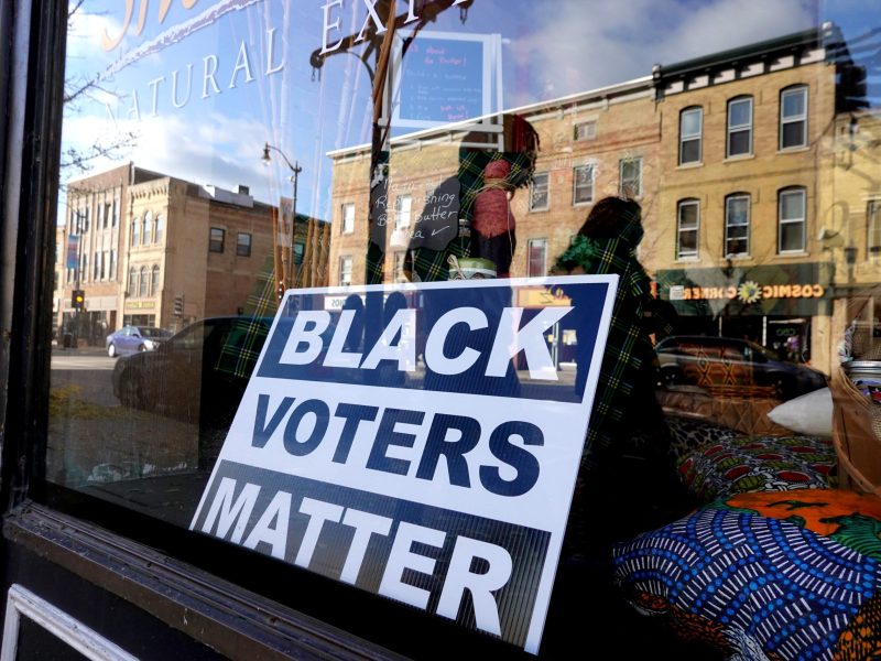 A sign reading "Black voters matter" sits in the window of a downtown storefront