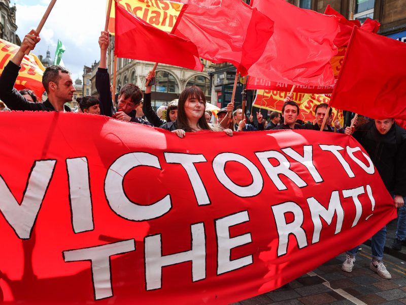 Protesters come out in support of striking RMT workers on June 25, 2022, in Glasgow, Scotland, holding a banner that reads "Victory to the RMT".