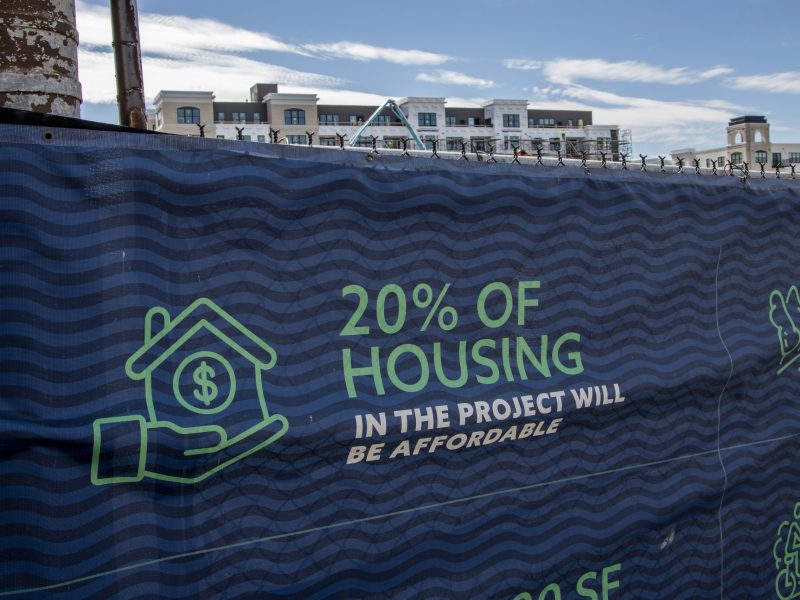 Fabric sign in front of a construction site that reads "20 percent of housing will be affordable."