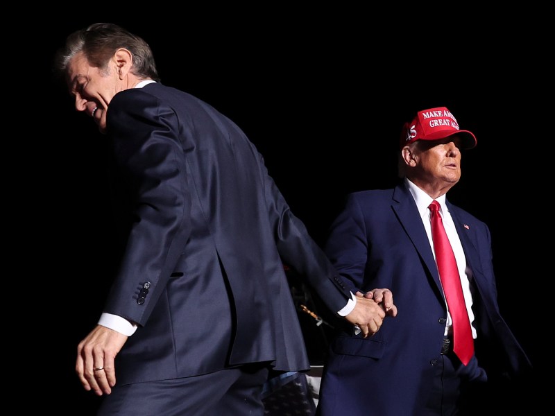 Pennsylvania Republican Senate candidate Dr. Mehmet Oz (L) shakes hands with former President Donald Trump during a rally at the Arnold Palmer Regional Airport on Nov. 5, 2022, in Latrobe, Pennsylvania.