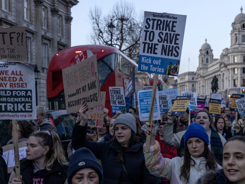 people holding signs in a street.