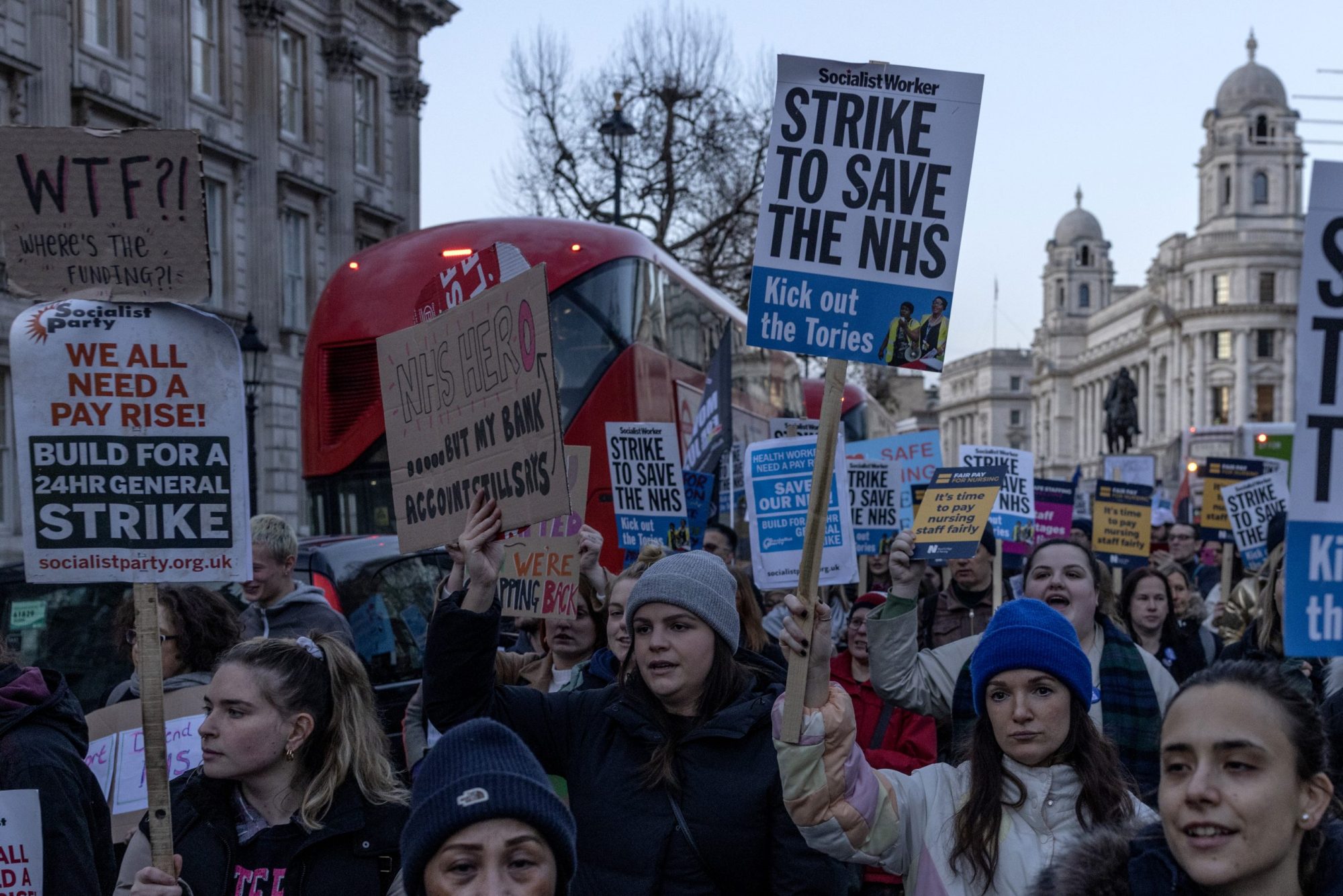people holding signs in a street.