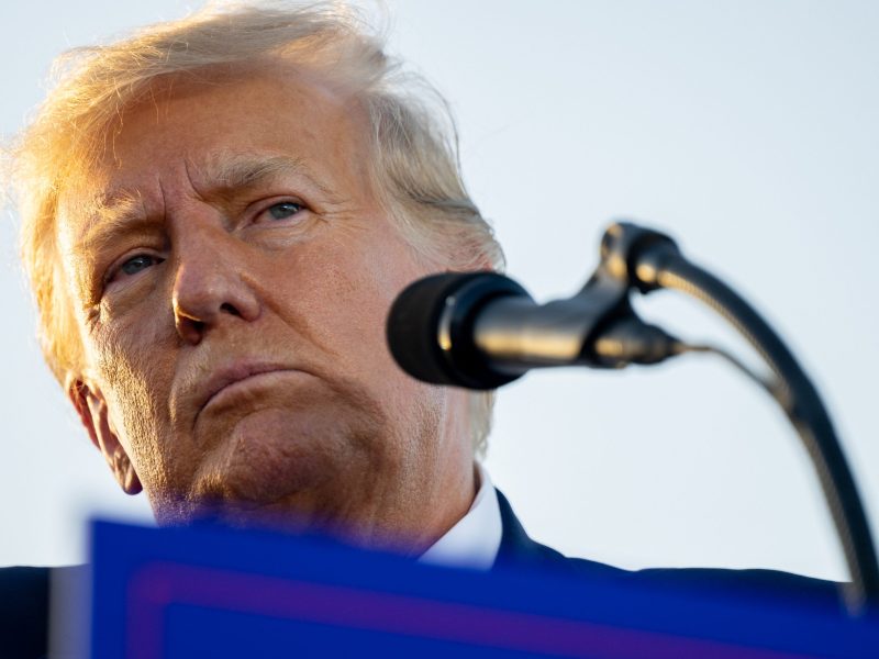 Close up of Donald Trump's face. He is grimacing in front of a microphone.