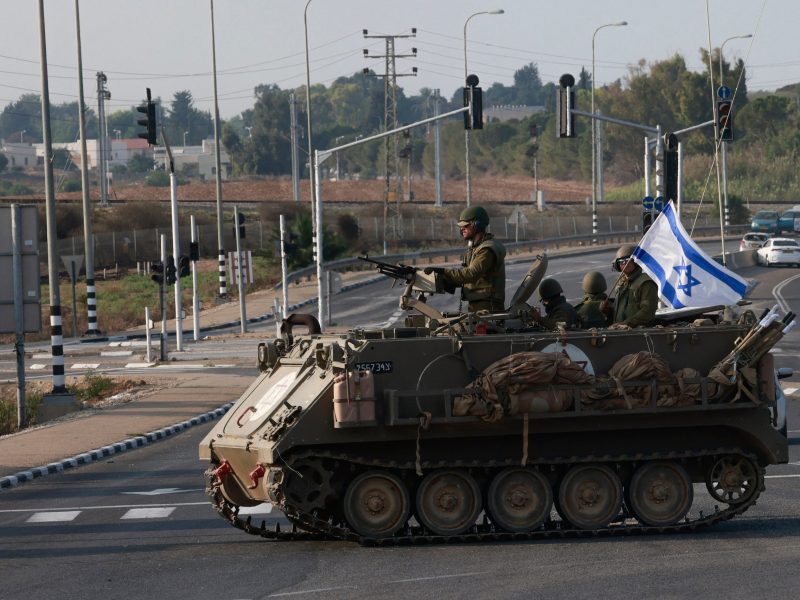 Israeli forces cross a main road in their armoured personnel carrier APC as additional troops are deployed near the southern city of Sderot on October 8, 2023. Photo by MENAHEM KAHANA/AFP via Getty Images