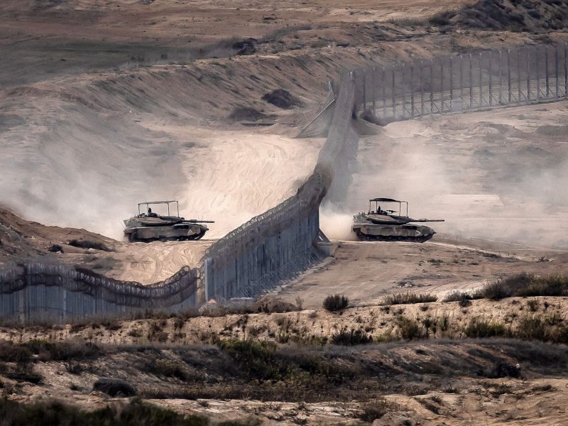Israeli tanks cross a barbed wire fence at a position along the border with the Gaza Strip and southern Israel on November 12, 2023, amid ongoing battles between Israel and the Palestinian militant group Hamas. Photo by FADEL SENNA/AFP via Getty Images