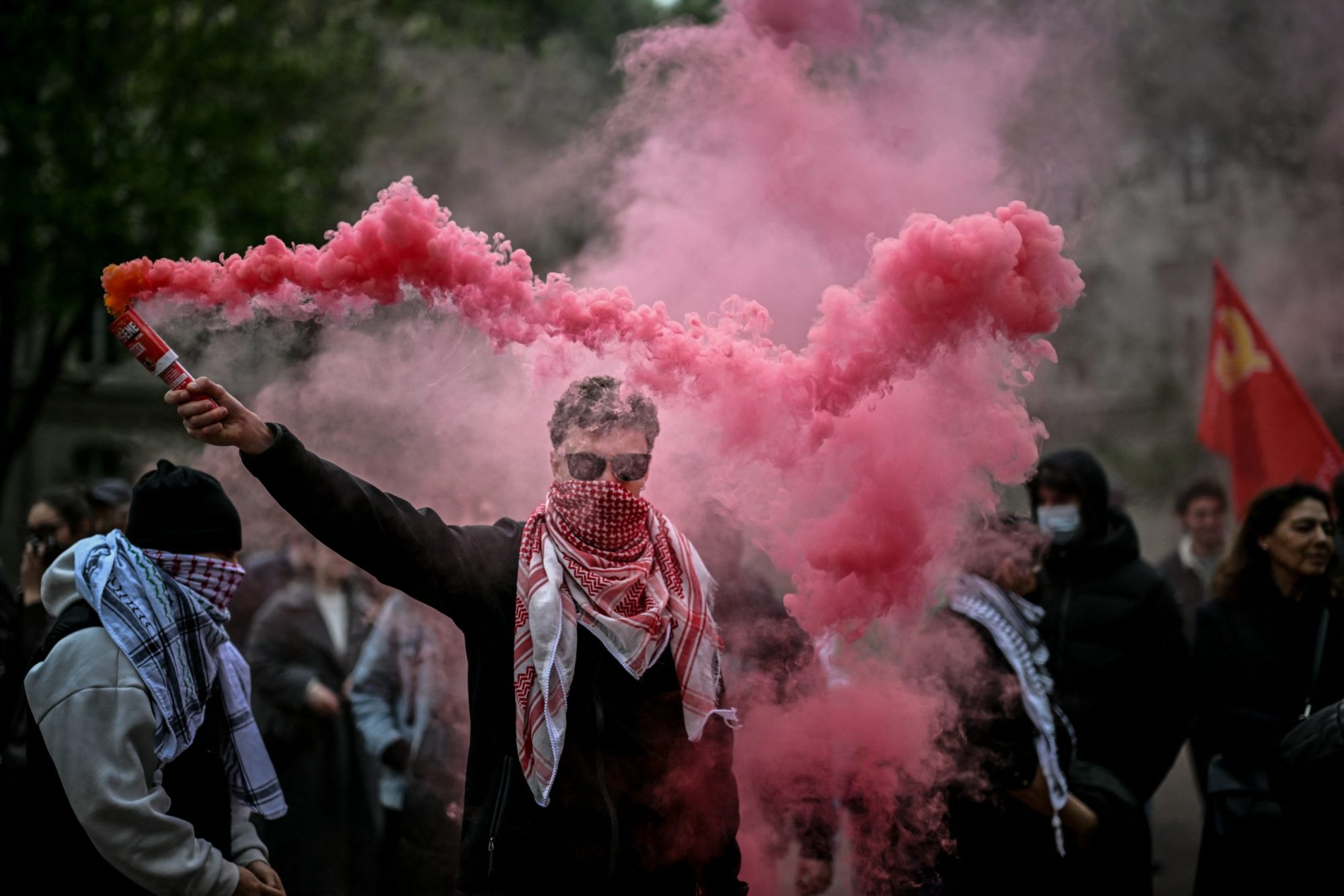 A demonstrator holds up flares during a pro-Palestinian demonstration in the courtyard of the Institute of Political Studies building in Lyon, central Eastern France, on April 30, 2024. Photo by OLIVIER CHASSIGNOLE/AFP via Getty Images