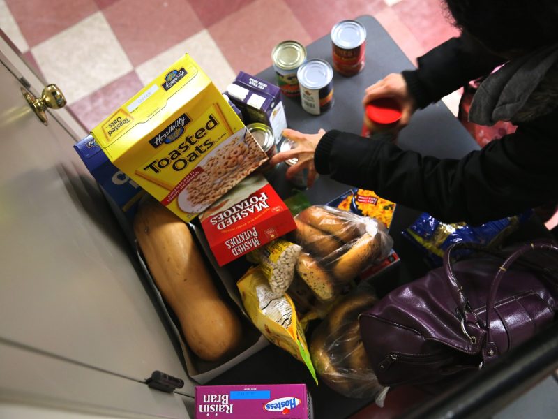 People receive free groceries at a food pantry run by the Food Bank For New York City on December 11, 2013 in New York City. Photo by John Moore/Getty Images.