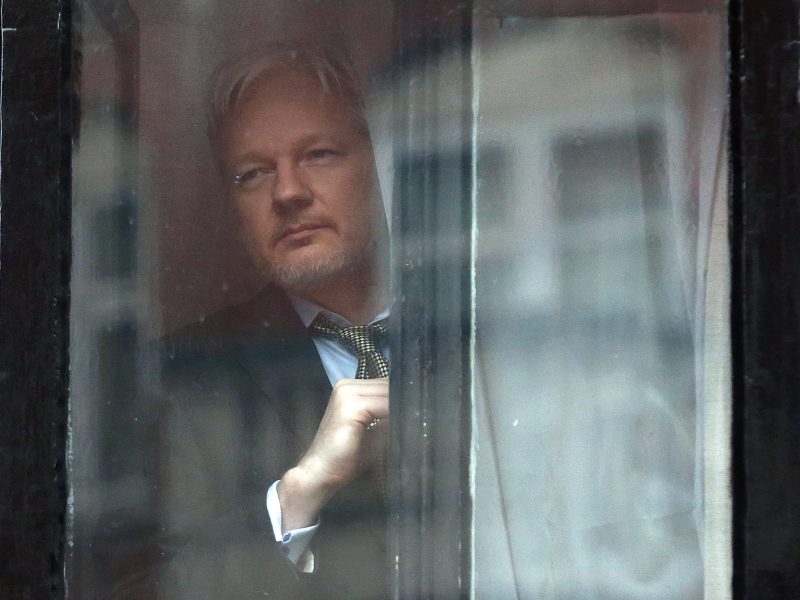 ﻿﻿Wikileaks founder Julian Assange looks out through a window of the Ecuadorian embassy in London