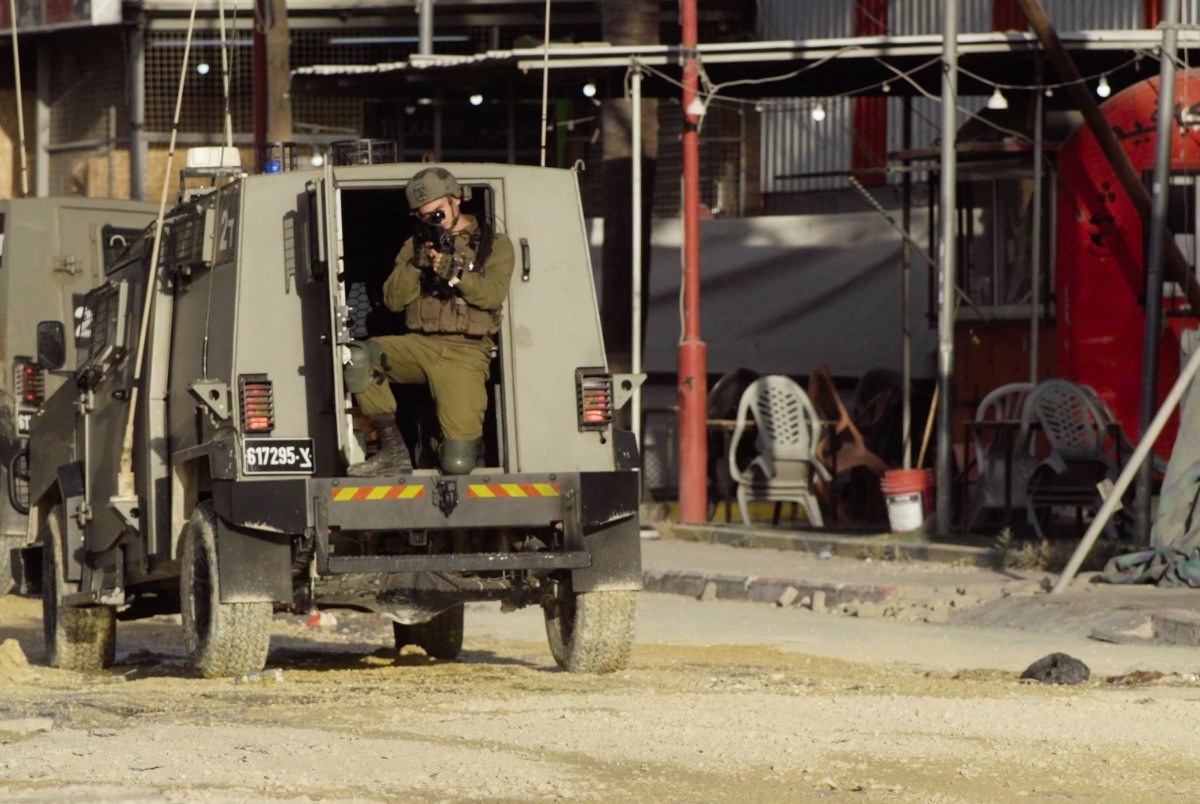 An IDF soldier trains his weapon at the camera during a raid on Nur Shams, West Bank, on April 18, 2024.