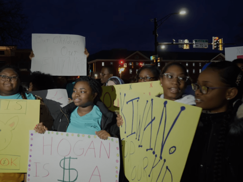 Baltimore City students holding signs protesting school underfunding